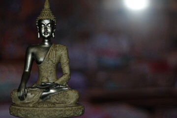 Earth Touching Buddha Statue with colorful backdrop with copy space, Bhumisparsha Buddha, Buddha in a seated meditation pose with his right hand touching the earth. 