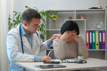 A young doctor, at his workplace, receives patients. He examines a disabled woman, without...