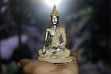 Serene Buddha Statue on hand empty colorful backdrop with copy space, yoga, meditation and...