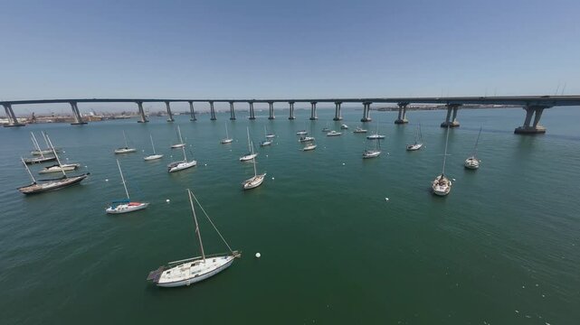 Drone footage of moored boats in San Diego Bay and Coronado Bridge in the background