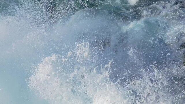 Drone shot of foamy waves breaking on the rocky shore of Seixo Branco Near Oleiros in A Coruna