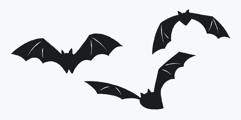 Silhouettes of three flying bats on a light background. Simple black bat illustrations. Halloween decoration concept for design and print.
