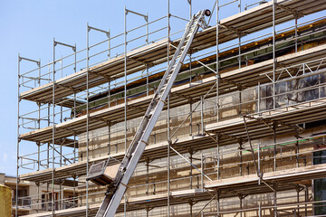 Scaffolding Equipment with Large Scaffolding Ladder in Construction Site. Professional Industrial Scaffolding for Building Construction Industry. 