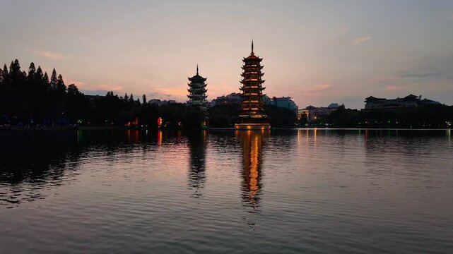Guilin, China: Panoramic view of the Sun and Moon pagodas reflection on the Shanhu pond in Guilin city in southwest china at sunset. 