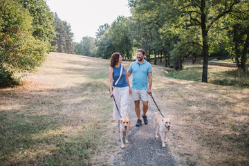 Couple enjoys park stroll with dogs