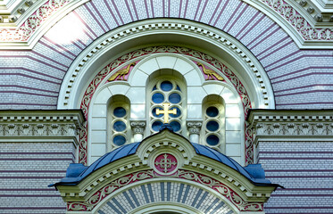 fachada de la iglesia con cruz y aves doradas