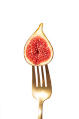 Half fig on a fork with vibrant red interior