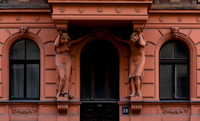 pareja de esculturas protegen la entrada del edificio rojo