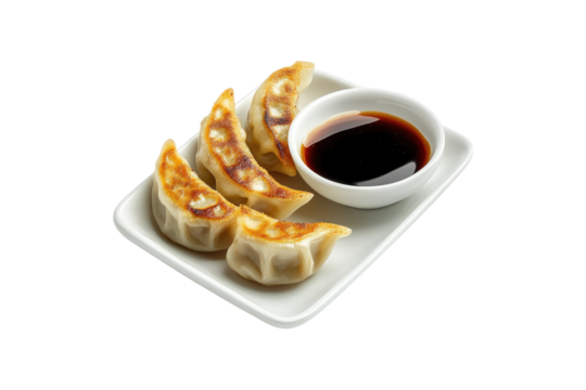 Savory gyoza dumplings with dipping sauce neatly on a transparent background