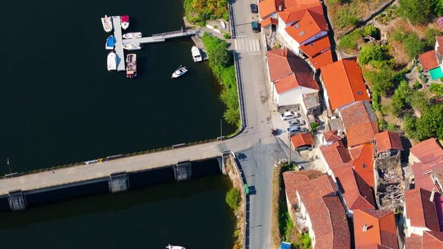 Drone view of houses and vineyards on the bank of Minho River near Ponte de Belesar in Lugo, Spain