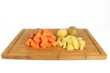 potatoes and sweet potatoes on chopping board isolated on white 