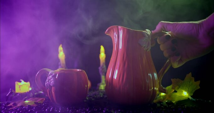 Pouring a hot drink into a pumpkin shaped Halloween teacup