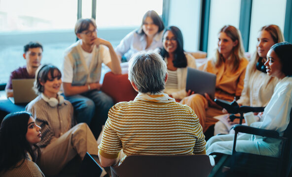 Multigenerational group gathered for a learning session with diverse students listening to an experienced speaker - Powered by Adobe