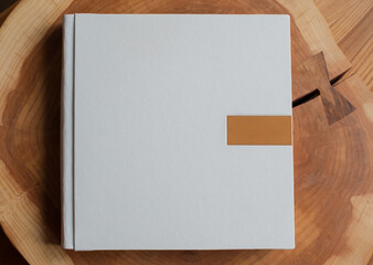 White photo album in leather cover on wooden table, copy space
