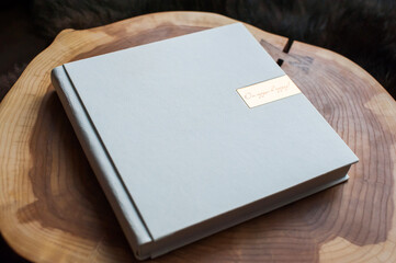 White photo album in leather cover on wooden table