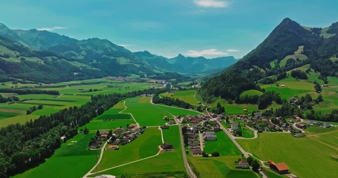 Medieval Swiss castle aerial view in summer. A drone flies through a green valley in the Swiss mountains. Famous Gruyere castle in Switzerland also called Schloss Greyerz, aerial shot by drone