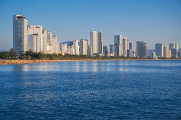 Fototapeta premium Panoramic view of the resort town of Nha Trang in Vietnam with a sandy beach by the sea and skyscrapers of hotels in summer