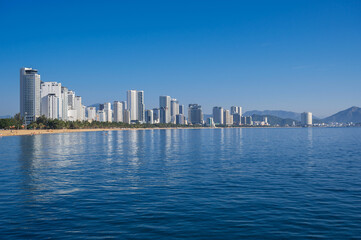 Fototapeta premium Panoramic view of the resort town of Nha Trang in Vietnam with a sandy beach by the sea and skyscrapers of hotels