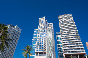 Fototapeta premium White facades of skyscraper hotels against the blue sky in summer in a resort town in Asia