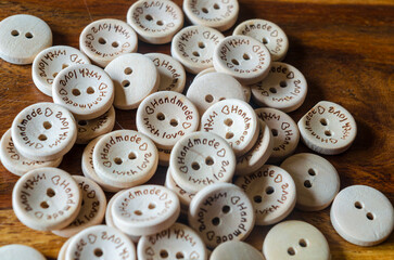 Close of hand made wooden buttons on a wooden background