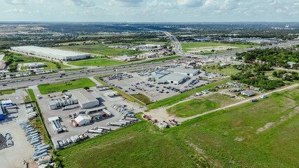 Busy interstate highway I-35 with overpass in industrial zonings manufacturer warehouse near large...