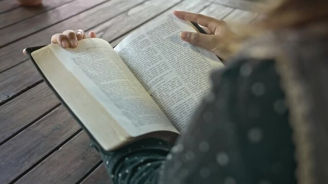 asian woman reading the Christian bible book on wooden table vintage room day time retro style