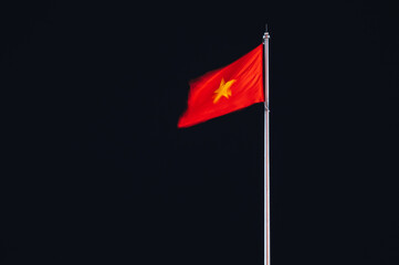 Vietnam flag blurred by the wind on flagpole at night