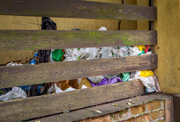 garbage behind the fence of an abandoned house. garbage scattered by homeless people