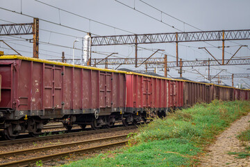 rail transport of coal and coal dust in freight wagons. non-ecological winter fuel. freight train standing at the railway station. wagons full of coal. view of the railway electrical network, high vol © Adam