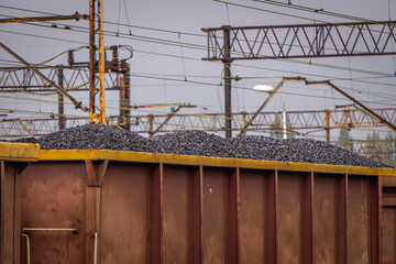 rail transport of coal and coal dust in freight wagons. non-ecological winter fuel. freight train standing at the railway station. wagons full of coal. view of the railway electrical network, high vol © Adam