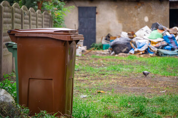 rubbish strewn loose in the yard of a tenement house. garbage in front of an abandoned building in the city center. © Adam