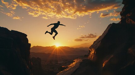 Obraz premium A silhouette of a person jumping between two rocky cliffs against a stunning sunset backdrop, symbolizing freedom and adventure.