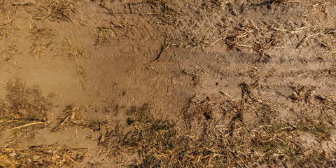 view from above on texture of dry muddy road with tractor tire tracks in countryside