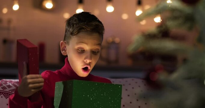 Little boy open gift box showing joy and surprise. Merry Xmas, Happy New Year, winter holidays
