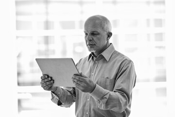 Senior manager using digital tablet in office building