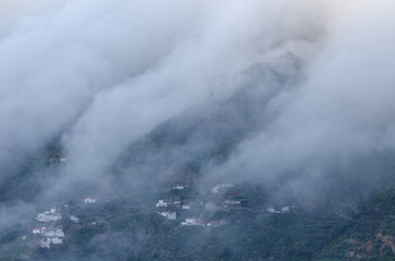 Sea of clouds falling over the caldera de Tejeda and village of Cuevas Caidas in the foreground. Tejeda. Gran Canaria. Canary Islands. Spain.