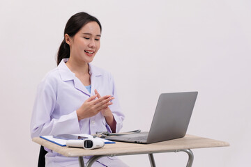Female doctor sitting at desk in hospital.