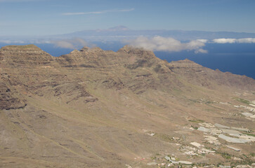 La Aldea valley, cliffs in the Special Natural Reserve of Guigui and island of Tenerife in the background. Gran Canaria. Canary Islands. Spain.