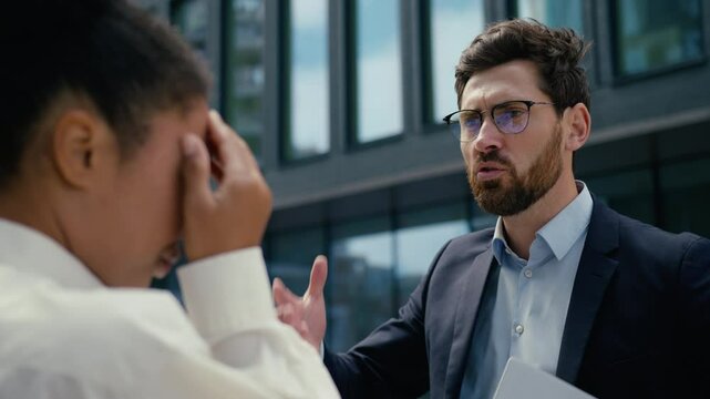 Multiracial business people problem stress in city multiethnic colleagues Caucasian businessman man male guy mad angry boss leader argument talk scold African woman businesswoman girl female sad upset