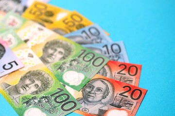 Few modern Australian dollar bills in different denominations lies on blue background