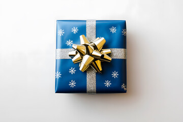 Wrapped gift in blue paper with silver snowflakes and a silver bow isolated on a white background