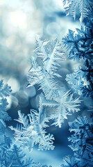 Frosty windowpane with intricate snowflakes creates mesmerizing winter scene, showcasing delicate ice patterns and serene blue background