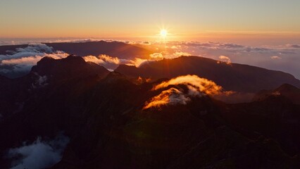 Aerial view of flying at Pico Ruivo of mountains with clouds on sunset. Madeira island, Portugal. Orbit parallax shot