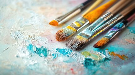 Obraz premium A vibrant arrangement of paintbrushes and a watercolor set on a white surface, with ample copy space, ideal for showcasing artistic creativity.