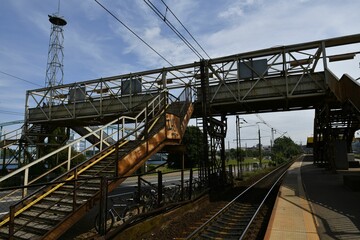 Fototapeta premium Urban railway station with metal pedestrian bridge.
