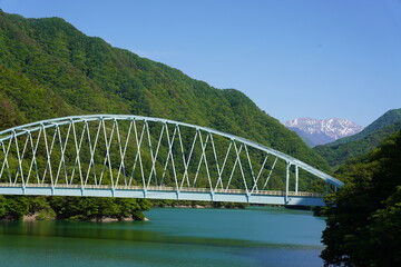 信州　大鹿村　エメラルドグリーンの小渋湖から残雪の赤石岳を望む