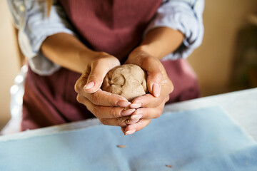 Female potter sculpts from clay at her workshop close-up