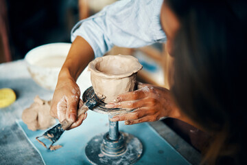 Female artist sculpts crafts with ceramic clay at her creative workshop