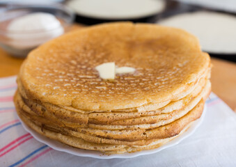 Cooking traditional pancakes from wheat flour in the kitchen