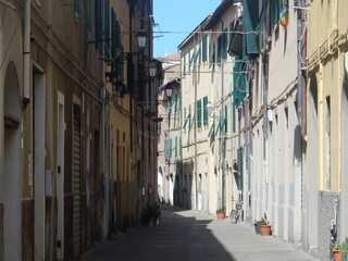 Fototapeta premium old houses facing a typical street in Piombino, Livorno Province, Tuscany, Italy